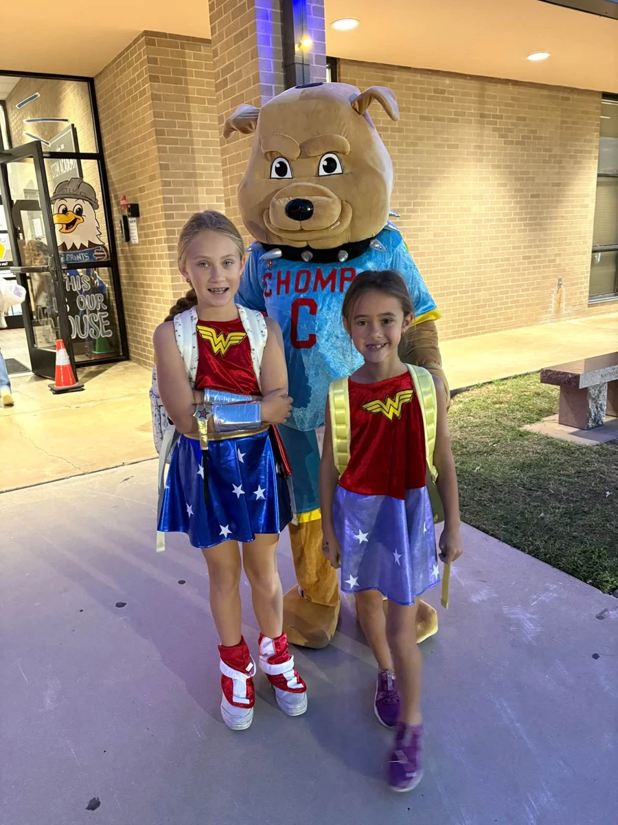 CHOMP mascot with two students in superhero costumes
