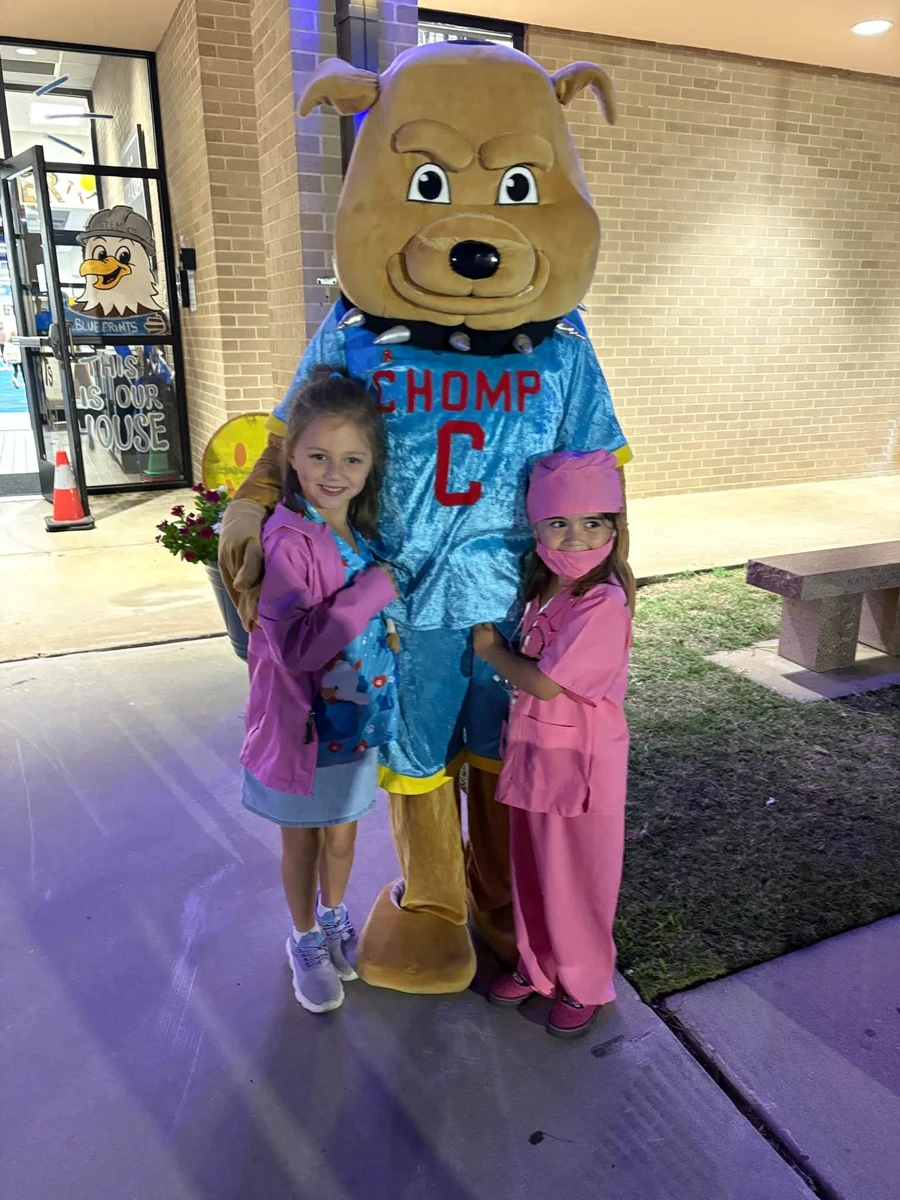 Two students posing with the CHOMP mascot